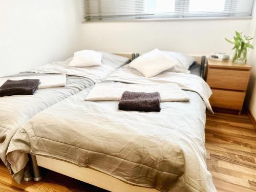 two beds in a bedroom with towels on them at DOMspitzen-BLICK, cooles 2 Zimmer Apt mit Küche und Smart-TV in Cologne