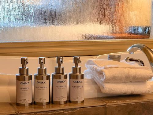 un bagno con quattro bottiglie di acqua ofodorizzatrice su un bancone di Long Beach Lodge Resort a Tofino