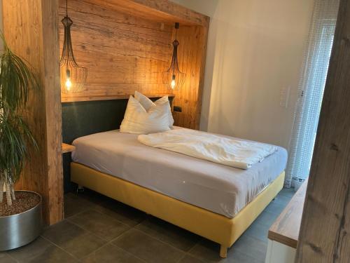 a bedroom with a bed with a wooden headboard at Apartments Bogner in Marktbergel