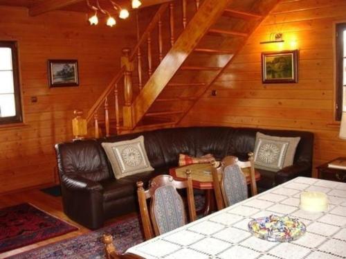 ein Wohnzimmer mit einem Ledersofa und einem Tisch in der Unterkunft Ferienhaus für Naturliebhaber 