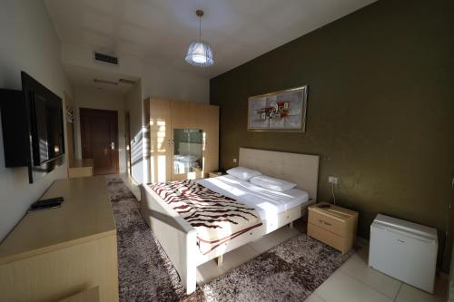a bedroom with a bed and a television in it at HOTEL GJUTA in Tirana