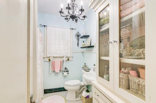 a bathroom with a white toilet and a chandelier at Pet-Friendly Galveston Bungalow, half Mi to Beach! in Galveston