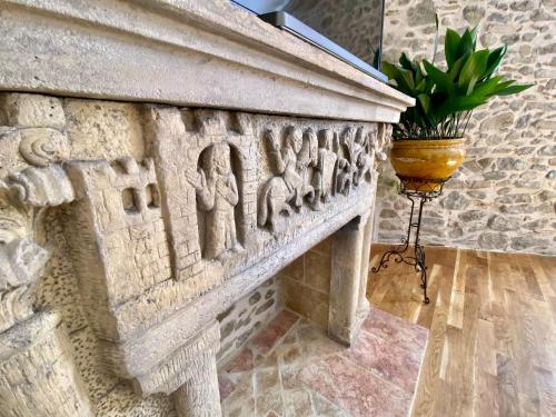 ein steinerner Kamin mit Reliefs an einer Wand in der Unterkunft La Maison des Templiers ~ Ostal Médiéval ~ Logis enchantés in Carcassonne