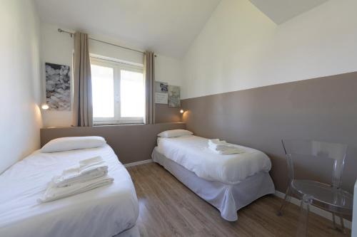 two beds in a hotel room with white sheets at Casa Vecchia Quercia in Assago