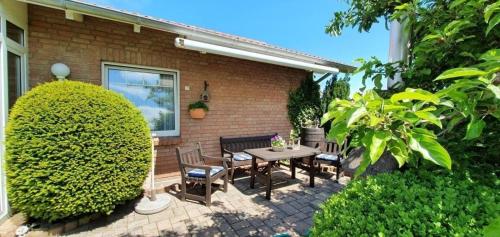 un patio con mesa y sillas frente a una casa en Sonnendurchflutetes Ferienhaus mit Wintergarten in Marienmünster mit schönem Garten und Terrassen en Marienmünster