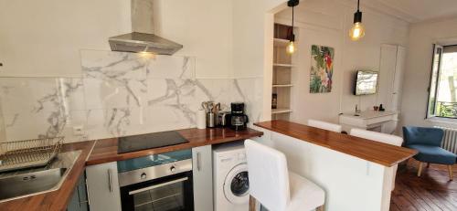 - une cuisine avec un comptoir et un lave-linge dans l'établissement Amazonia Rouen Centre by MyFrenchPAT, à Rouen