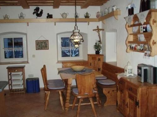 Große Wohnung in Bayerisch Eisenstein mit Großer Terrasse في بايريش أيزنشتاين: مطبخ مع طاولة وكراسي في غرفة