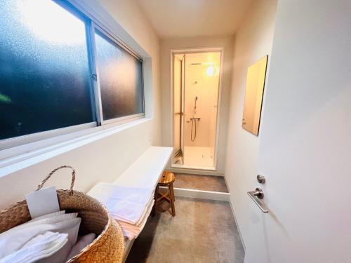 Zimmer mit einer Tür, einem Fenster und einer Bank in der Unterkunft CONNECT, - Vacation STAY 33451v in Arita