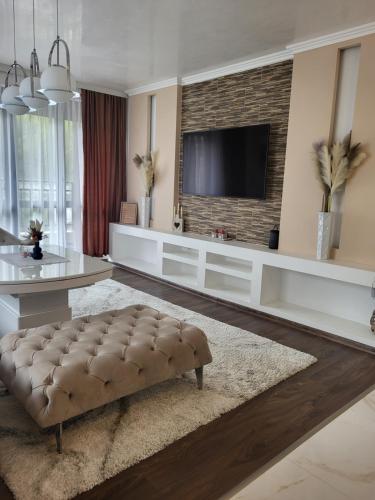 uma sala de estar com televisão numa parede de tijolos em Luxury apartment em Teteven