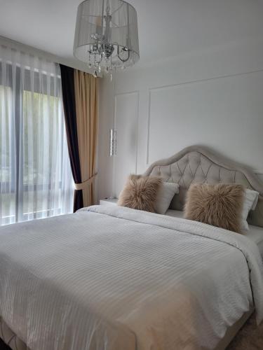 a bedroom with a large white bed with a chandelier at Luxury apartment in Teteven
