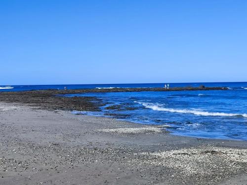una playa con agua azul y una costa rocosa en Casa Lagarto Beachfront, en Venado