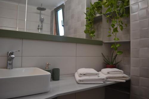 ein Badezimmer mit einem Waschbecken und Handtüchern auf der Theke in der Unterkunft Loupino Family House in Stoupa