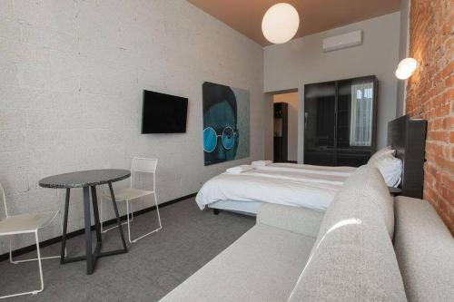 een slaapkamer met een bed, een tafel en een bank bij Resume Apartments, Reporter Corner No 5 by URBAN RENT in Kaunas
