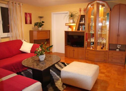 a living room with a red couch and a table at Wunderschönes Ferienhaus in Zainingen mit Eigener Terrasse in Zainingen