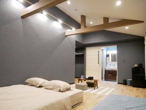 ein Schlafzimmer mit einem weißen Bett und einer blauen Wand in der Unterkunft HOOD - Vacation STAY 19686v in Amami