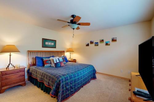 a bedroom with a bed and a ceiling fan at Cascades Townhomes by Steamboat Resorts in Steamboat Springs