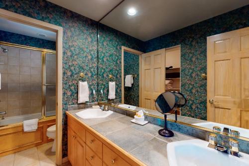 een badkamer met 2 wastafels en een grote spiegel bij Cascades Townhomes by Steamboat Resorts in Steamboat Springs