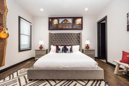 1 dormitorio con 1 cama grande y 2 mesas en 2 Stylish Gulch Town Homes - Rooftop Hot Tub - Sleeps 24, en Nashville