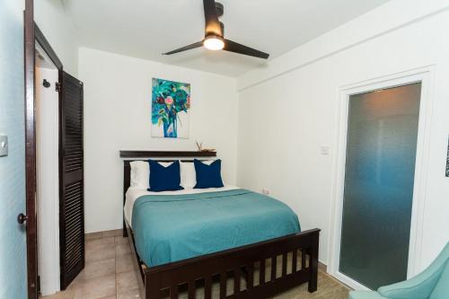 a bedroom with a bed with a ceiling fan at Hodges Bay House in Calibishie