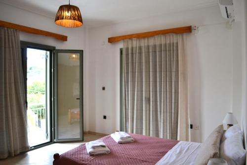 ein Schlafzimmer mit einem Bett mit zwei Handtüchern darauf in der Unterkunft Loupino Family House in Stoupa
