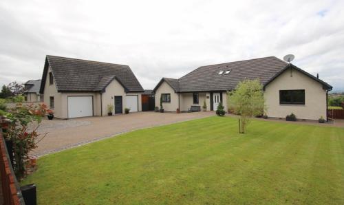 a house with a lawn in front of it at Brohar Annexe in Inverness