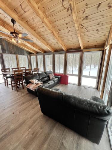 a living room with a leather couch and a table at THE RIVER HOUSE LIMIT 6 home in Hiram