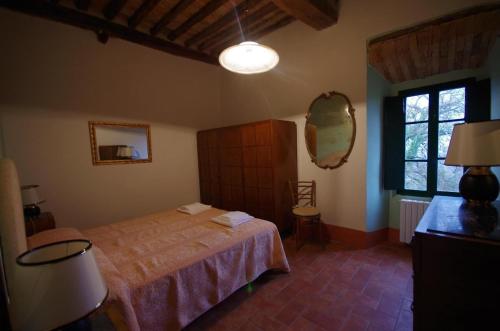 Schlafzimmer mit einem Bett und einem Wandspiegel in der Unterkunft Studio für 4 Personen ca 60 qm in Monteriggioni, Toskana Chianti in Monteriggioni