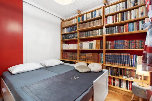 a bed in a room with bookshelves at ARIA Superior Apartment, Seaview & Wellness in Portorož