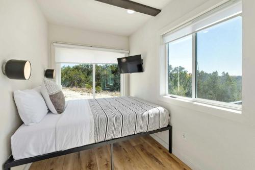 een slaapkamer met een bed en een raam bij Hill Country Norwood Tiny Home A- On 13 Acres & Sleeps 2 and Pet Friendly! in Dripping Springs