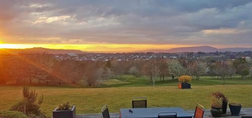 a view of a field with the sunset in the background at Brohar Annexe in Inverness
