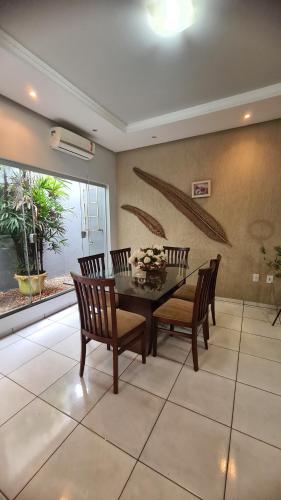 une salle à manger avec une table et quatre chaises dans l'établissement Casa mobiliada para periodo TECNOSHOW, à Rio Verde