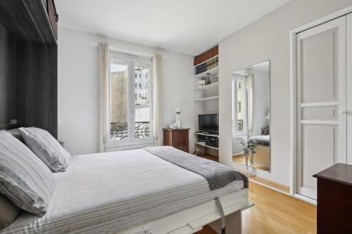 une chambre blanche avec un lit et une fenêtre dans l'établissement Studio St Dominique - Invalides - B'Your Home, à Paris