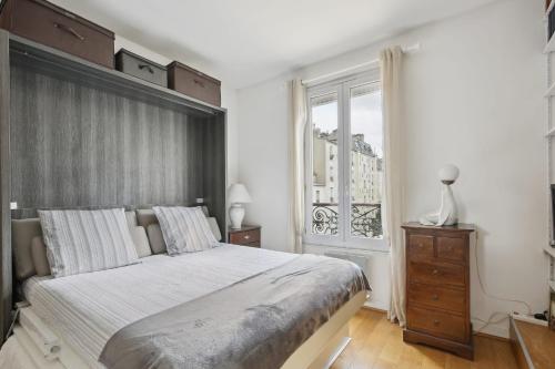 une chambre avec un grand lit et une fenêtre dans l'établissement Studio St Dominique - Invalides - B'Your Home, à Paris