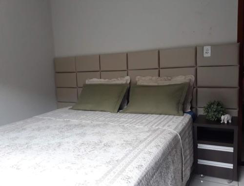 リオ・ベルデにあるCasa mobiliada para periodo TECNOSHOWのベッドルーム1室(大型ベッド1台、緑の枕2つ付)