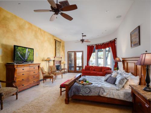 a bedroom with a bed and a couch and a tv at Scottsdale - 35982 N Willow Cross Dr in Cave Creek