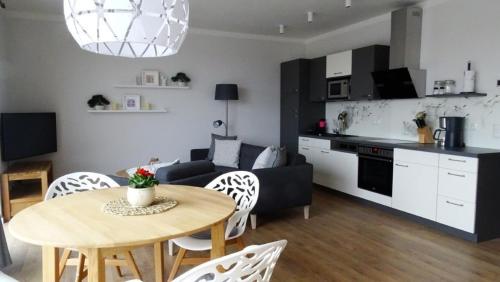 Il dispose d'une cuisine et d'un salon avec une table et un canapé. dans l'établissement Ferienwohnung Wünnowblick mit Sauna, à Röbel