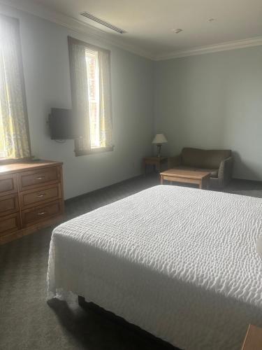 a bedroom with a white bed and a couch at Harbor House Inn in Sackets Harbor