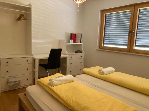 1 dormitorio con 2 camas, escritorio y silla en Dantin guest house en Prvačina