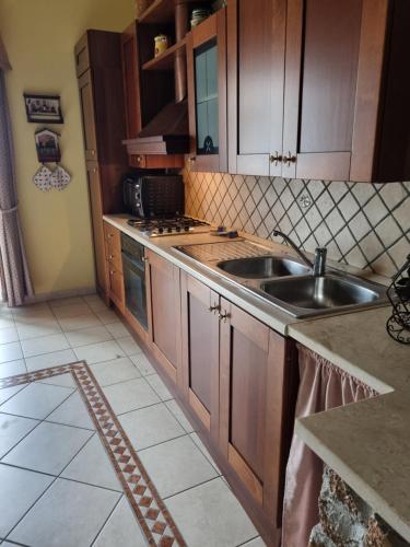 a kitchen with wooden cabinets and a sink at Elìsim House in Caiazzo