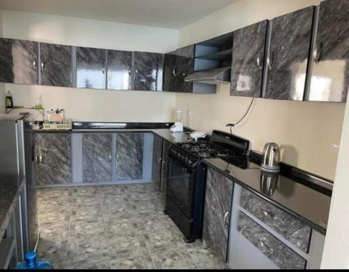 a kitchen with black cabinets and a stove top oven at Casa rossi in Tecolutla