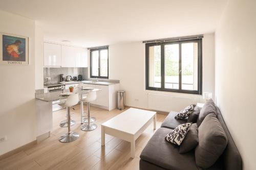 a living room with a couch and a kitchen at Le Berceau ~ T2 Spacieux ~ Proche Paris & RER A in Nogent-sur-Marne