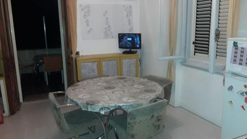 a room with a table and chairs and a television at Bilocale con vista mare e monti a Cala Gonone in Cala Gonone