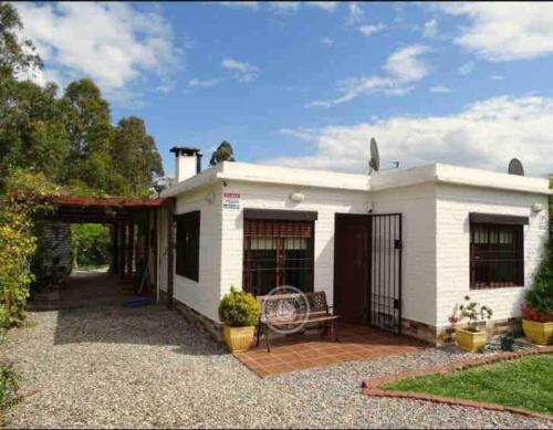 uma casa branca com um banco num quintal em Hermosa casa, jacuzzi climatizado em Bella Vista