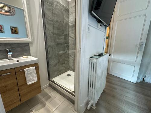 uma casa de banho com uma cabina de duche ao nível do chão ao lado de um lavatório em 4P Terrasse, Palais à 500 m, Charme Bourgeois em Cannes