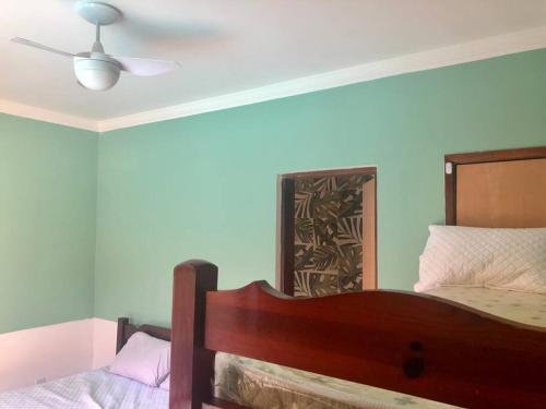 Schlafzimmer mit einem Bett und einem Deckenventilator in der Unterkunft Edícula/Casa de hóspedes: 3 dorms 3 banheiros, piscina 7x5, churrasqueira, 150m do mar in Mongaguá