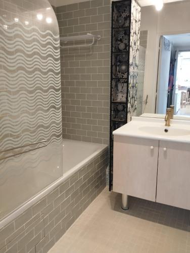 une salle de bain avec un lavabo, une douche et une baignoire dans l'établissement Appartement proche Village Olympique au pied du métro Carrefour Pleyel, à Saint-Denis