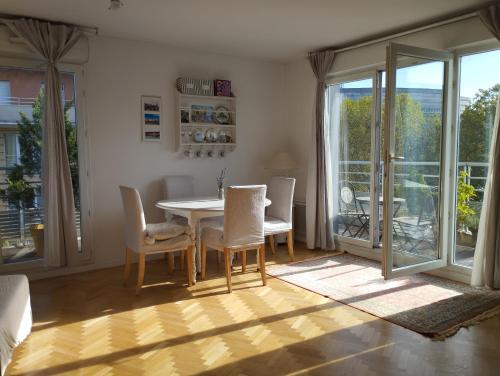 une salle à manger avec une table et des chaises dans l'établissement Appartement proche Village Olympique au pied du métro Carrefour Pleyel, à Saint-Denis