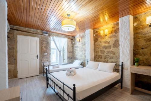 a bedroom with a bed with a teddy bear on it at İmerek Taş Ev Otel Alaçatı in Alaçatı