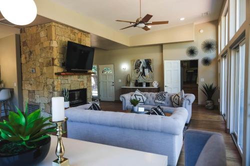 a living room with couches and a stone fireplace at ULTIMATE Mountain Escape with Pool & Hot Tub & Firepit in Sedona