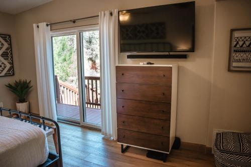 a bedroom with a dresser next to a sliding glass door at ULTIMATE Mountain Escape with Pool & Hot Tub & Firepit in Sedona